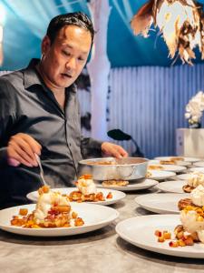 a man sitting at a table with plates of food at Sea Love Beach Bar & Bungalows in Ban Tai