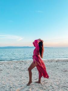 a girl in a pink dress walking on the beach at Sea Love Beach Bar & Bungalows in Ban Tai