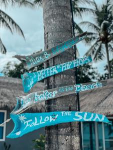 a pole with street signs attached to a tree at Sea Love Beach Bar & Bungalows in Ban Tai