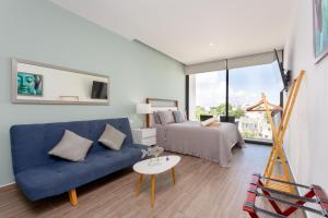 Una sala de estar con un sofá azul y una cama. en Edificio Vanessa 24 studios, en Playa del Carmen 124 fotos más