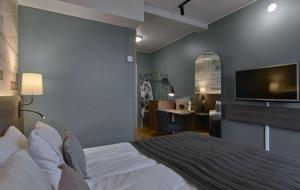 a bedroom with a large bed with a flat screen tv at Scandic Opalen in Gothenburg