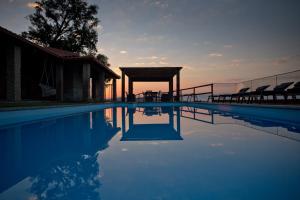 a swimming pool with a gazebo and the sunset at Casa do Sobreiro in Celorico de Basto