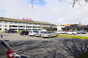 un parking avec des voitures garées devant un bâtiment dans l'établissement Scandic Helsingborg Nord, à Helsingborg