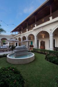 a large building with a fountain in the middle of a yard at Hotel la Perla Leon in León