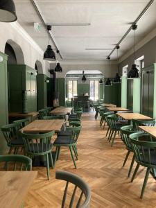 une cafétéria avec des tables en bois et des chaises vertes dans l'établissement Gästehaus Phantasie, à Eisenach