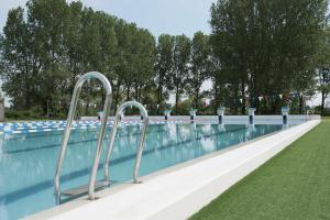 a swimming pool with a row of metal hand rails at Scandic Segevång in Malmö