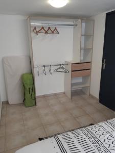 Zimmer mit einem Schrank und einem Schreibtisch. in der Unterkunft Gîte la Parent'Aise in Fressenneville