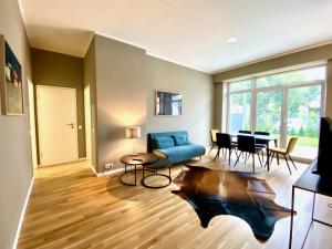 a living room with a blue couch and a table at LIVING Apartments Leipzig in Leipzig