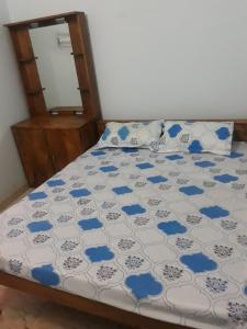 Schlafzimmer mit einem Bett mit einer blauen und weißen Bettdecke in der Unterkunft Mahadev Guest House And Resort in Dhamtari