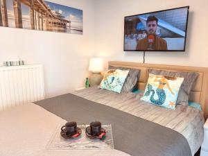 1 dormitorio con 2 camas y TV en la pared en CITY PREMIUM Studio Suite en Blankenberge