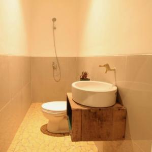 a bathroom with a sink and a toilet in it at Cabana Surf and Stay in Biha