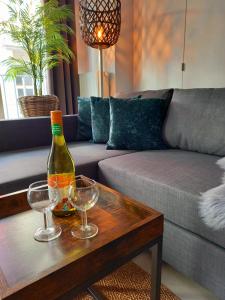 a living room with a bottle of wine and two glasses on a table at CITY PREMIUM Studio Suite in Blankenberge