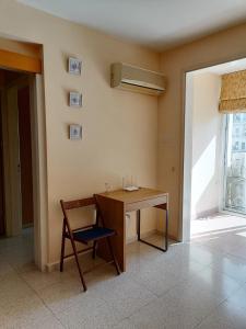 escritorio y silla en una habitación con ventana en St Nikolas 1bdm Apartment, FREE Wi-Fi & Parking, en Nicosia