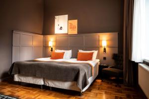 a bedroom with a large bed with orange pillows at Scandic Grand Central in Stockholm