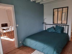 Ce lit se trouve dans une chambre dotée d'un mur bleu. dans l'établissement Maison avec jardin dans petit bourg typiquement Percheron - Le Colombier, à Boissy-Maugis
