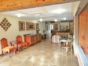 a living room with tables and chairs and a kitchen at Apartotel Don Francisco in San José