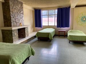 a hospital room with two beds and a fireplace at Kasa Kiwi Hostel & Travel Agency in Quetzaltenango +26 photos