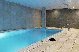 a swimming pool with blue water in a room at Scandic Örebro Väst in Örebro