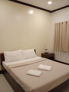een slaapkamer met een bed met twee handdoeken erop bij AB Star Suites in General Santos