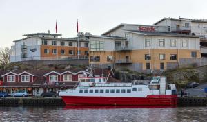 a red and white boat sitting in the water at Scandic Laholmen in Strömstad