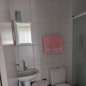 a bathroom with a sink and a toilet and a window at Praia da Cachoeira in Florianópolis