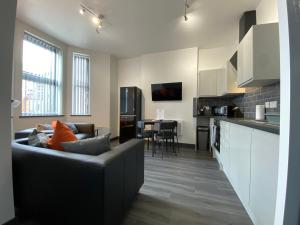 a living room and kitchen with a couch and a table at StayCrewe Apartments in Crewe