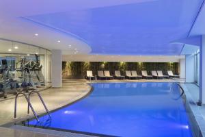 una piscina in un hotel con palestra di Ramada Hotel & Suites by Wyndham Izmir Kemalpasa a Kemalpaşa