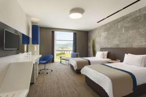 Postel nebo postele na pokoji v ubytování Ramada Hotel & Suites by Wyndham Izmir Kemalpasa