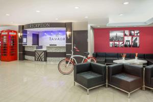 a lobby with a red phone booth and a bike at Ramada by Wyndham Miami Springs/Miami International Airport in Miami