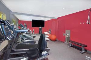a gym with cardio equipment and a red wall at Ramada by Wyndham Miami Springs/Miami International Airport in Miami