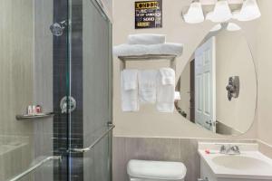 a bathroom with a sink toilet and a mirror at Ramada by Wyndham Miami Springs/Miami International Airport in Miami