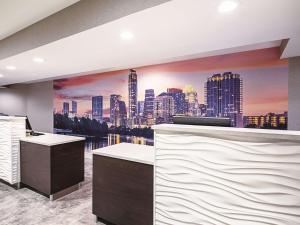 a bar with a city skyline mural on the wall at La Quinta by Wyndham Austin Airport in Austin