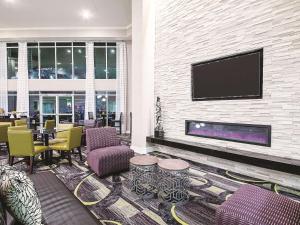 a lobby with a fireplace and a tv on a wall at La Quinta by Wyndham Austin Airport in Austin