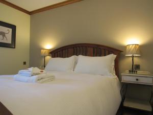 a bedroom with a large white bed with two lamps at The Vestry in Chichester