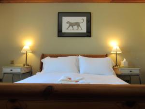 a bedroom with a bed with two lamps and a lion picture on the wall at The Vestry in Chichester