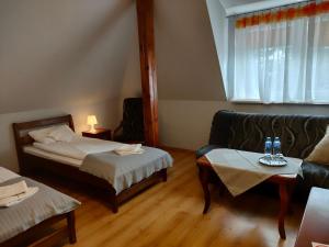 a hotel room with two beds and a couch at Dworek Zawadzkich in Kruszyn