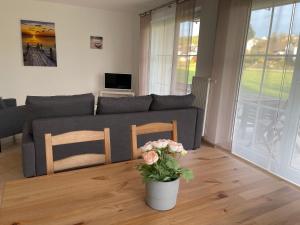 uma sala de estar com um sofá e um vaso com flores em Apartment Mühlbach em Bad Abbach