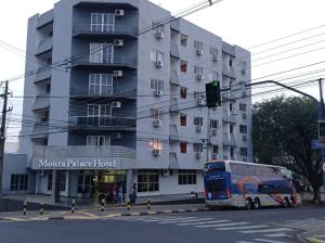 un autobús está estacionado frente a un edificio en Moura Palace Hotel, en Foz do Iguaçu