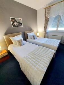 Hotel Villa Valpovo في Valpovo: سريرين يجلسون بجانب بعض في غرفة النوم