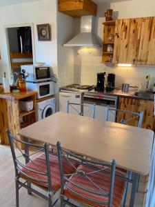 a kitchen with a wooden table and a stove at Les Myrtilles Pyrénées 2000 in Bolquere Pyrenees 2000