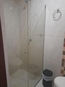 a shower with a glass door next to a toilet at Hostal Casa Mathias in Cartagena de Indias