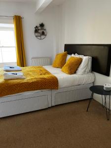 a bedroom with a large bed with yellow pillows at Queens Hotel in Blaenau-Ffestiniog