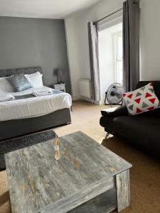 a living room with a bed and a coffee table at Queens Hotel in Blaenau-Ffestiniog