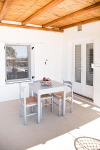 una mesa blanca y sillas en un patio en Andria's suites, en Chrissi Akti