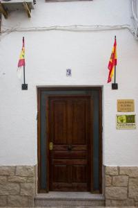 un edificio con dos banderas delante de una puerta en Casa Rural Placida, en Escalona