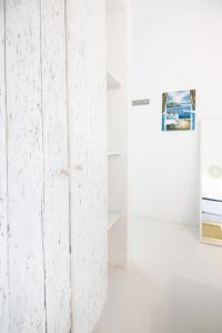 eine weiße Wand in einem weißen Zimmer mit einer Tür in der Unterkunft Andria's suites in Chrissi Akti