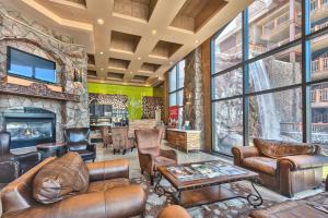 a living room with leather furniture and a stone fireplace at Westgate Park City Differentiated Modern Update Top Floor View Deluxe 2 Bedroom in Park City