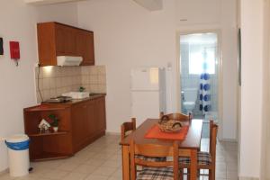 a kitchen with a table with a cat sitting on it at Rosmaris Apartments in Plataniás