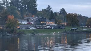 a house on the shore of a body of water at Valois Motel & Restaurant in Mattawa