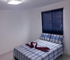 ein Bett mit zwei roten Samthandschuhen drauf. in der Unterkunft Natal Conforto in Natal